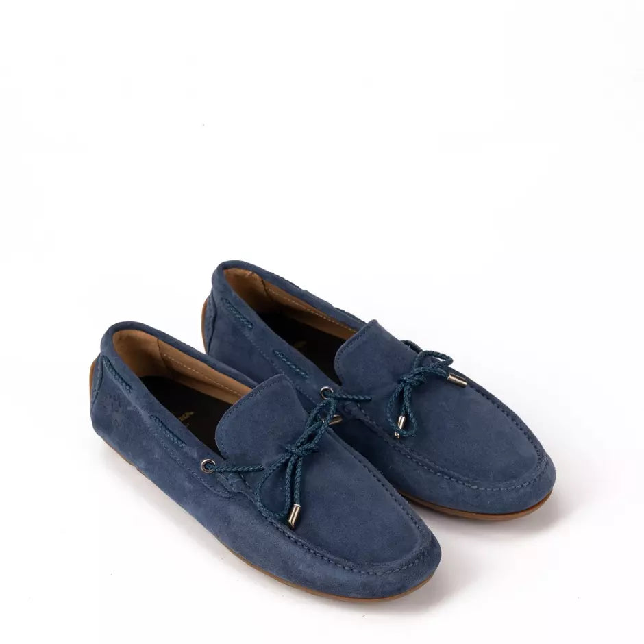 A pair of blue suede moccasins with a leather bow on the top