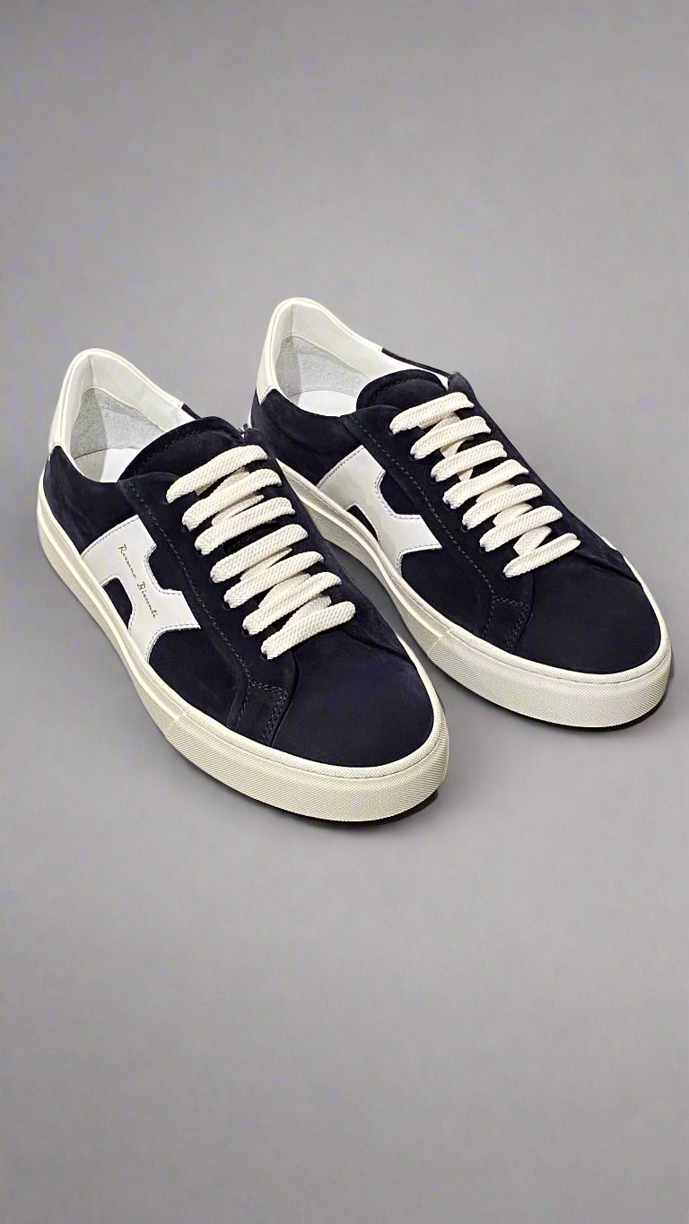 Pair of navy and white sneakers on a light gray surface