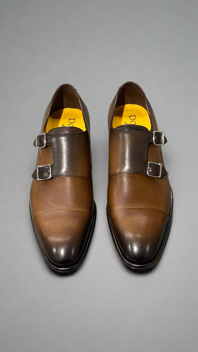 Brown leather shoe with a buckle on a light gray background