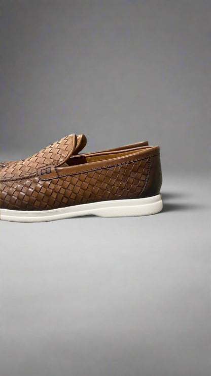 Brown woven loafer with white sole on a gray surface