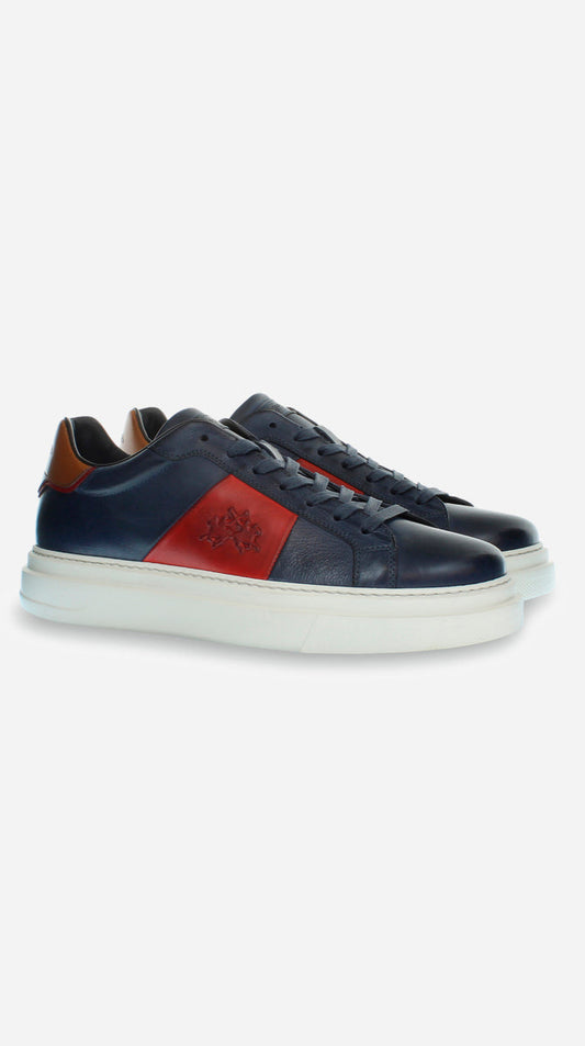 Navy sneakers with a red patch on a white background